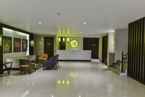 A modern lobby with a reception desk, seating area, and a staircase. - Lemon Tree Hotel Jammu (Jammu)