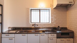 Cocina con armarios blancos, estufa de acero inoxidable y una ventana sobre el lavamanos.