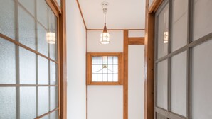 Un pasillo estrecho con piso de madera y puertas correderas tradicionales japonesas.