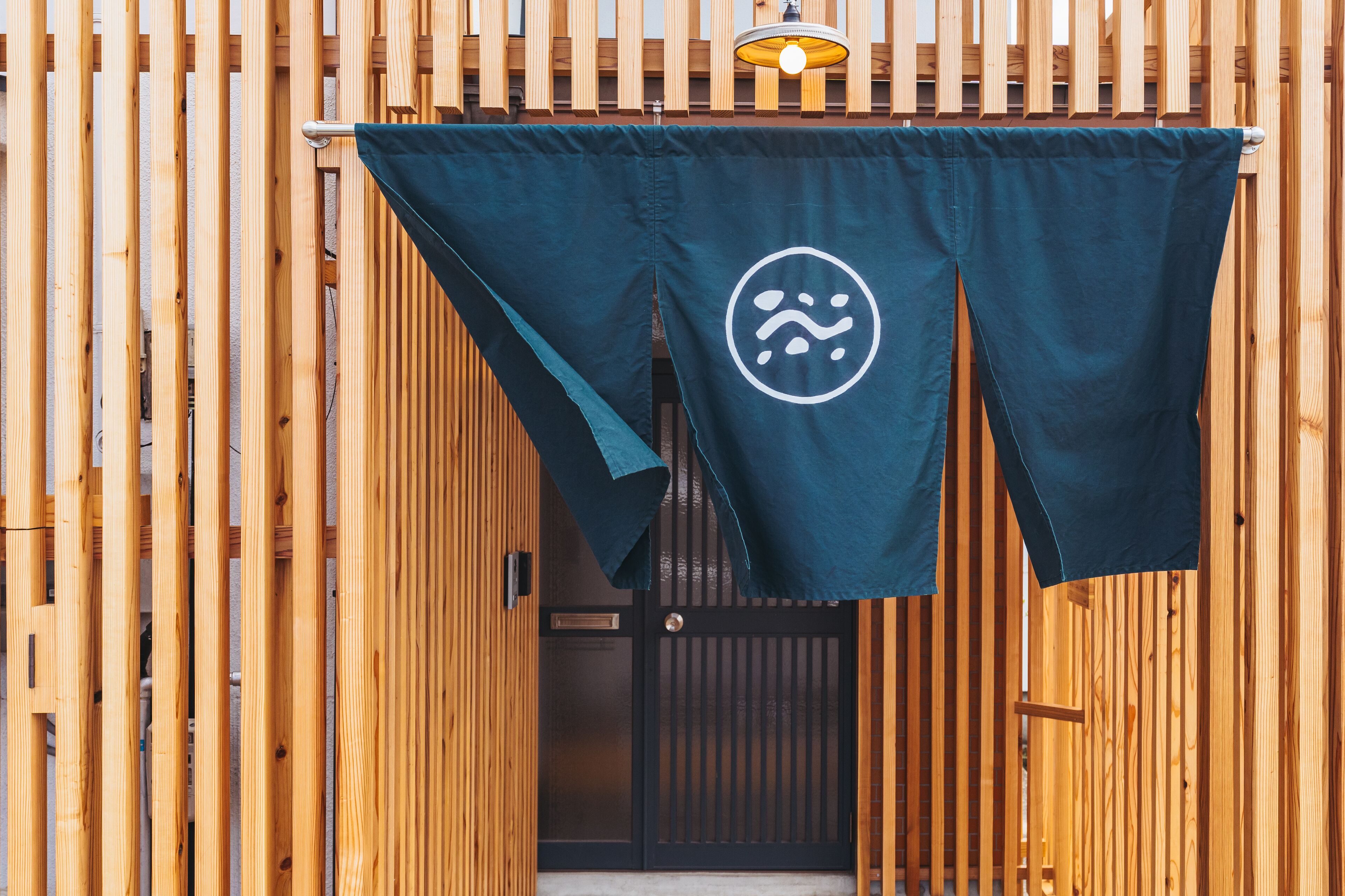 A wooden gate with a dark blue cloth hanging over it, featuring a white logo.