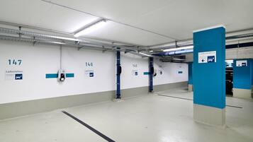 A clean, well-lit parking garage with numbered parking bays and clear signage for Ladestation.