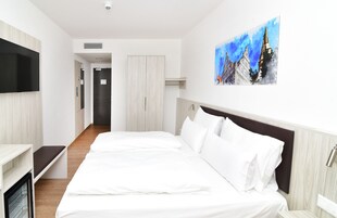 Ropa de cama hipoalergénica y caja de seguridad en la habitación