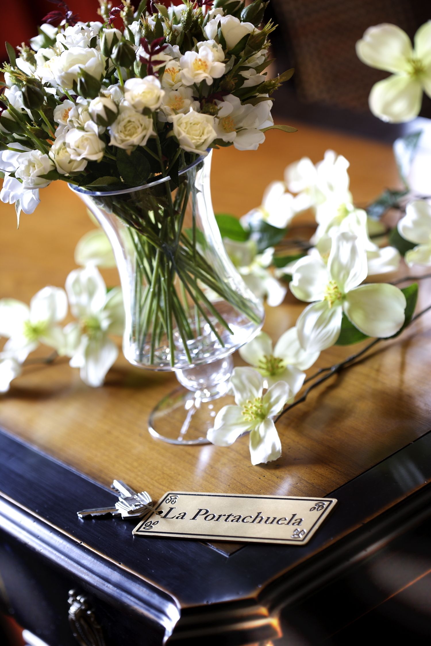 Een vaas met witte bloemen op een houten ondergrond.