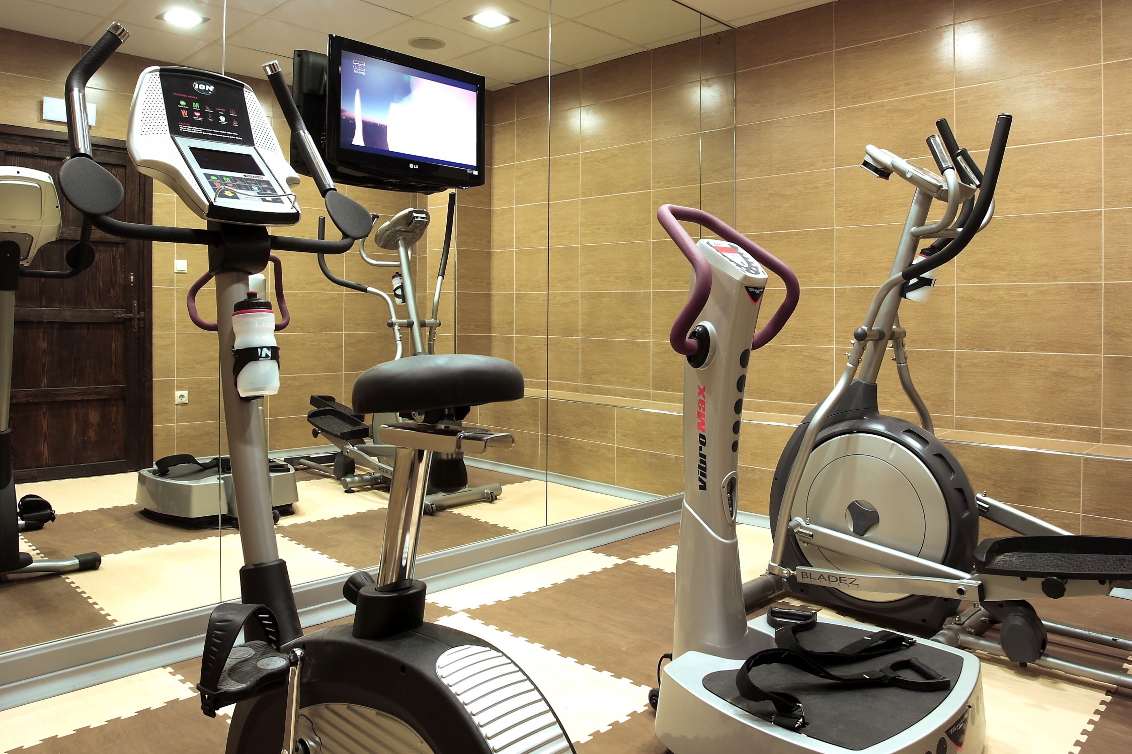 A gym with stationary bikes, a treadmill, and a rowing machine.