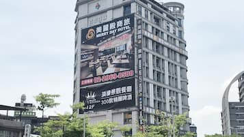 A hotel with a large sign advertising 'Merry Day Hotel' and 'Happy Day Hotel'.