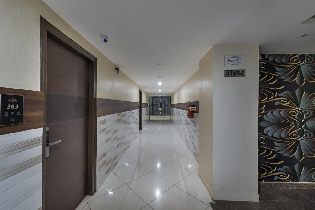 Pasillo de hotel con un cartel que indica la habitación 303, un símbolo de WiFi y un letrero del cuarto piso.