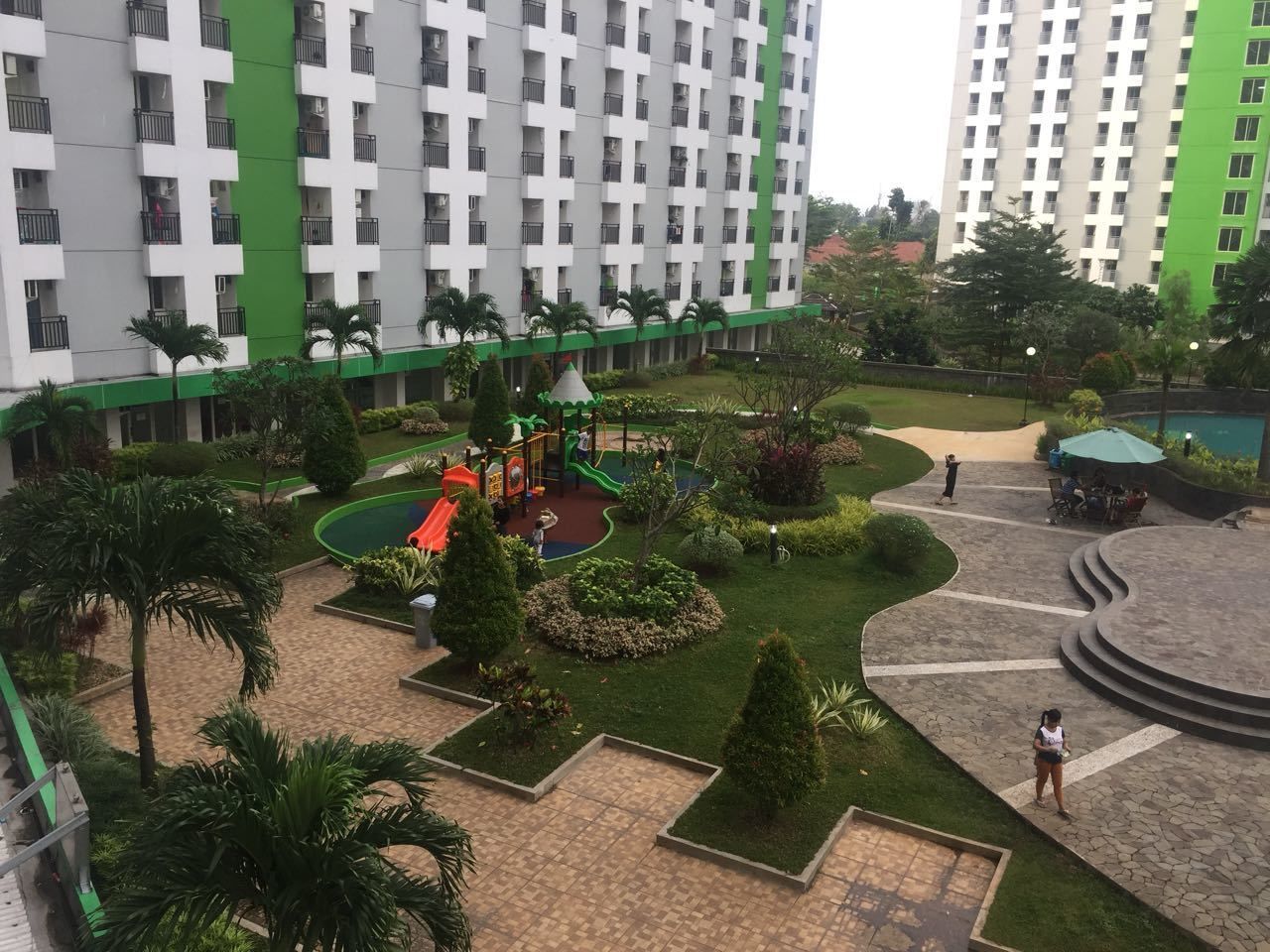 A residential complex with a playground, landscaped gardens, and a central courtyard.