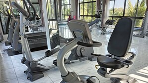 A gym with various exercise equipment, including a stationary bike and a rowing machine. - Eireann Boutique Hotel (Prakhon Chai)