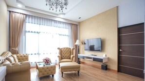 A modern hotel room with a large window, a sofa, a chair, a TV, and a wooden floor. - Eireann Boutique Hotel (Prakhon Chai)