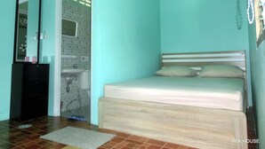 Un dormitorio con cama, espejo, lavabo y piso de baldosas.