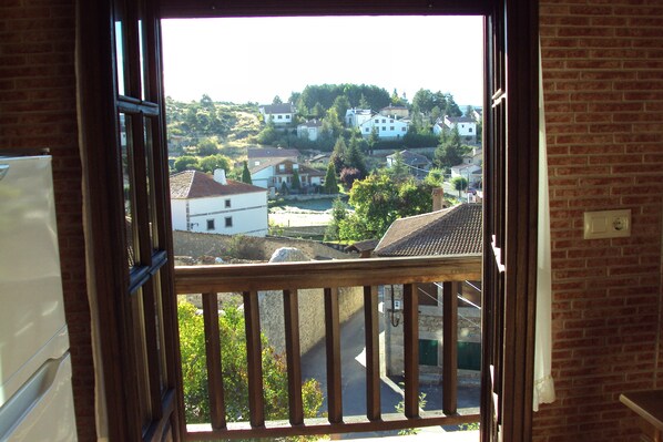 A view from a balcony with a brick wall and a wooden railing.