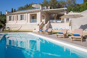 A modern villa with a swimming pool, sun loungers, and a hammock. - Villa Pelekas (Corfu)