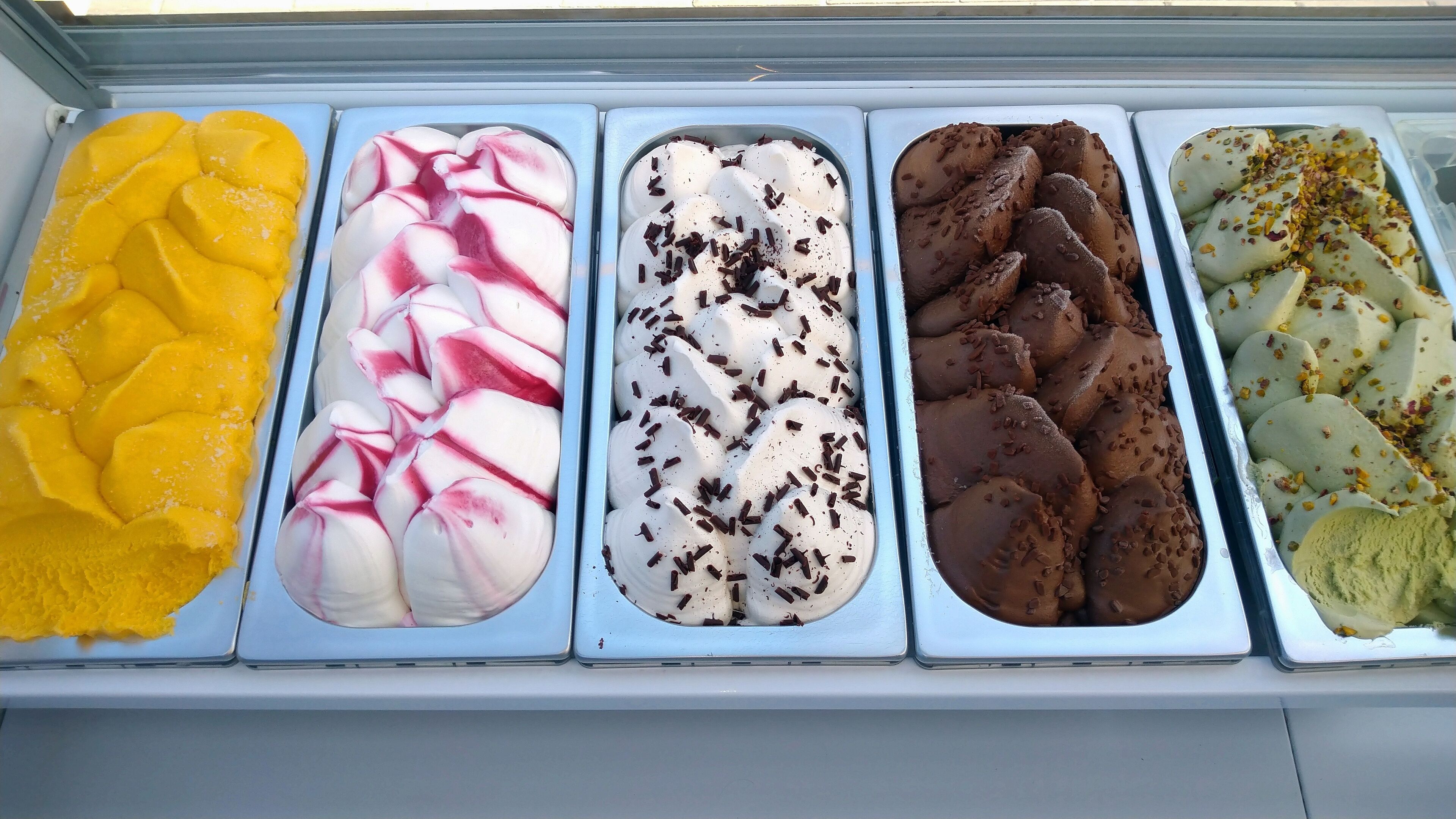 Un espositore di dolci con diversi gusti di gelato.
