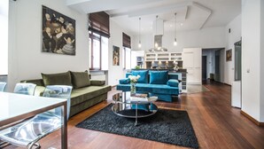 A modern living room with a sofa, a coffee table, and a dining area. - Krakow B&B Luxury Old Town (Kraków)