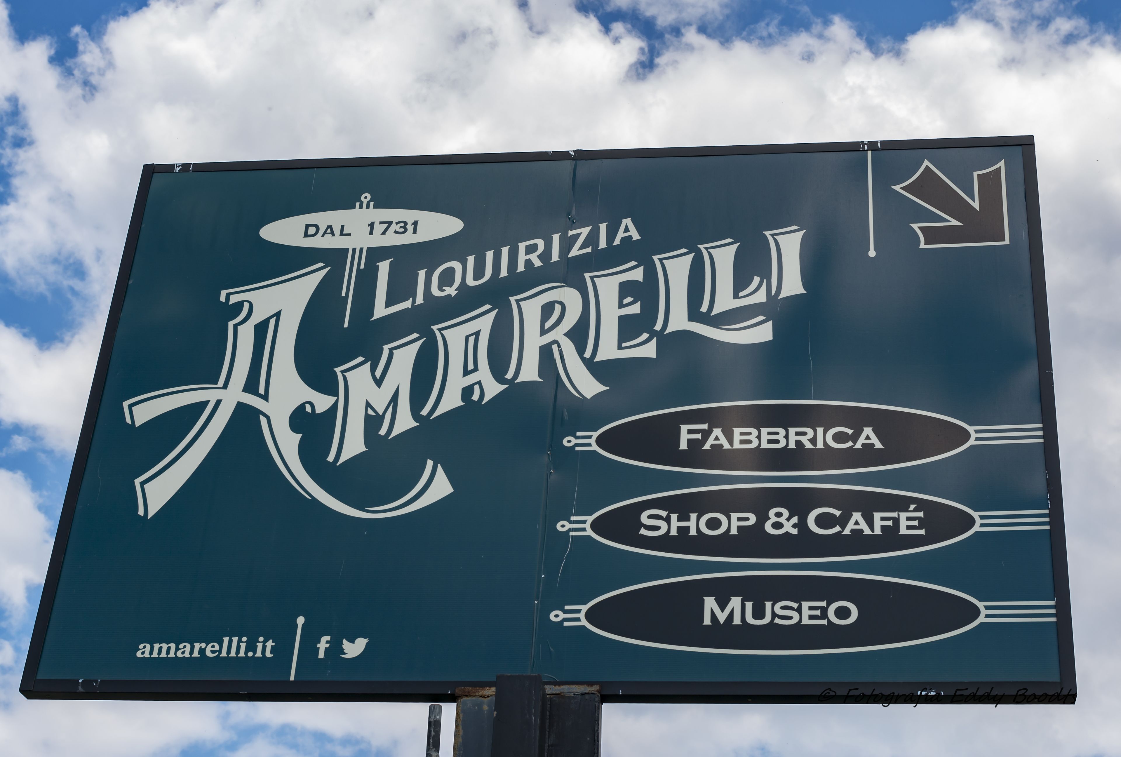 A sign for 'A Marelli' with sections labeled 'Fabrica,' 'Shop & Café,' and 'Museo.'