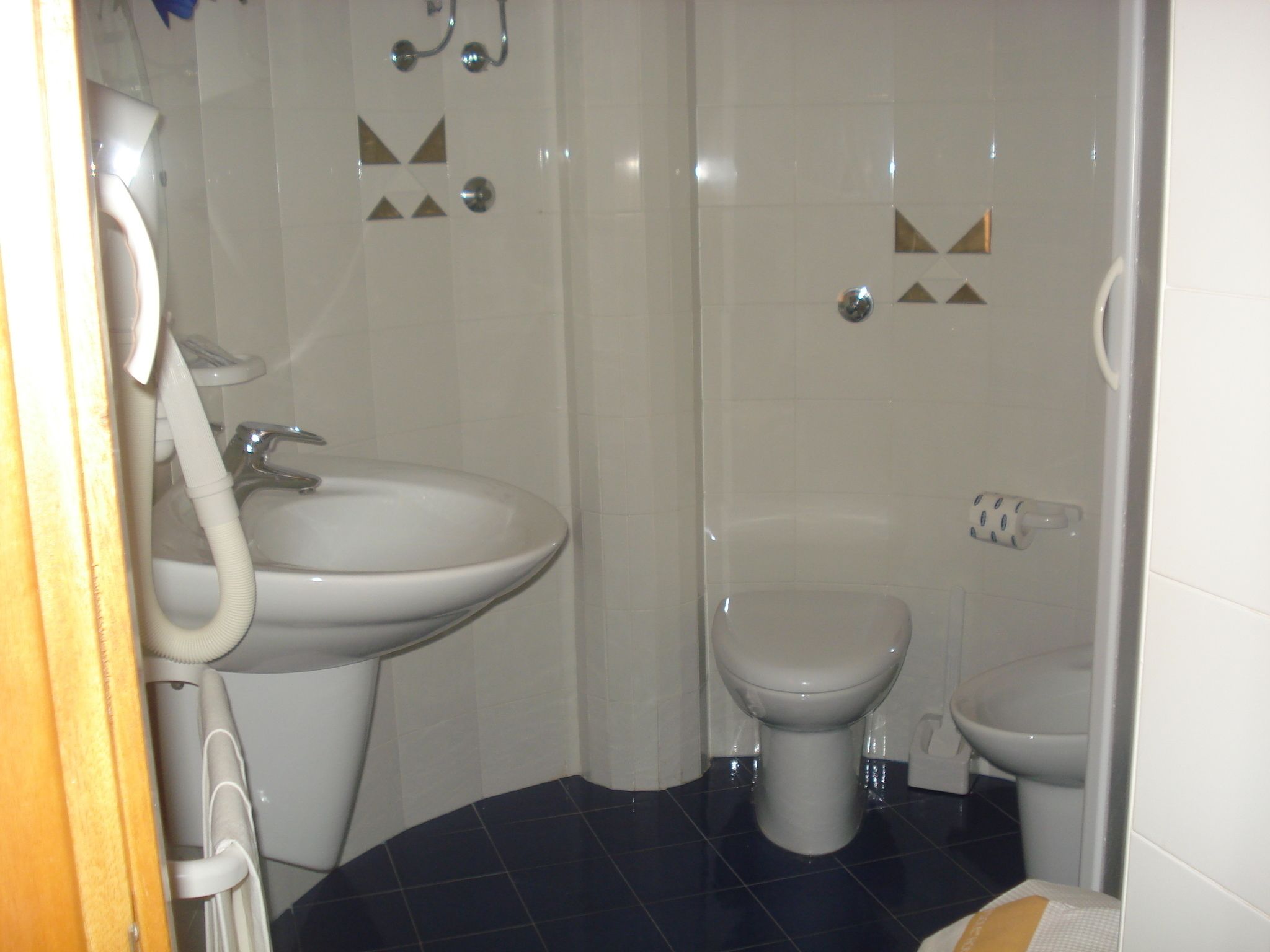 A bathroom with a sink, toilet, and bidet.