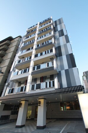A multi-story hotel with a modern design, featuring balconies on each floor and a prominent entrance with a covered walkway. - Hotel Chuo Selene (Osaka)