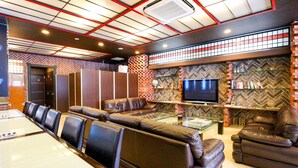 A modern lounge with leather seating, a glass coffee table, and a flat-screen TV. - Hotel Chuo Selene (Osaka)