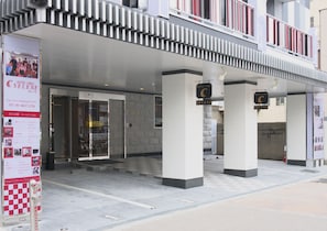 A hotel entrance with a modern design, featuring a checkered floor pattern and a prominent entrance with glass doors. - Hotel Chuo Selene (Osaka)