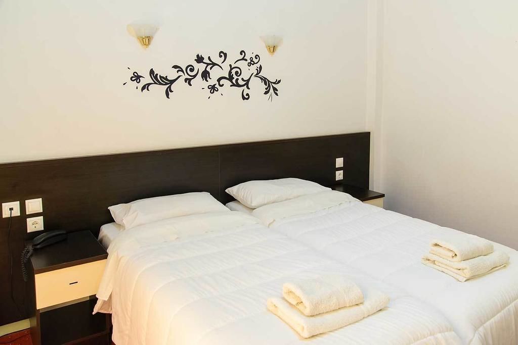 Ein Hotelzimmer mit Doppelbett, zwei Nachttischen und Wanddekoration.