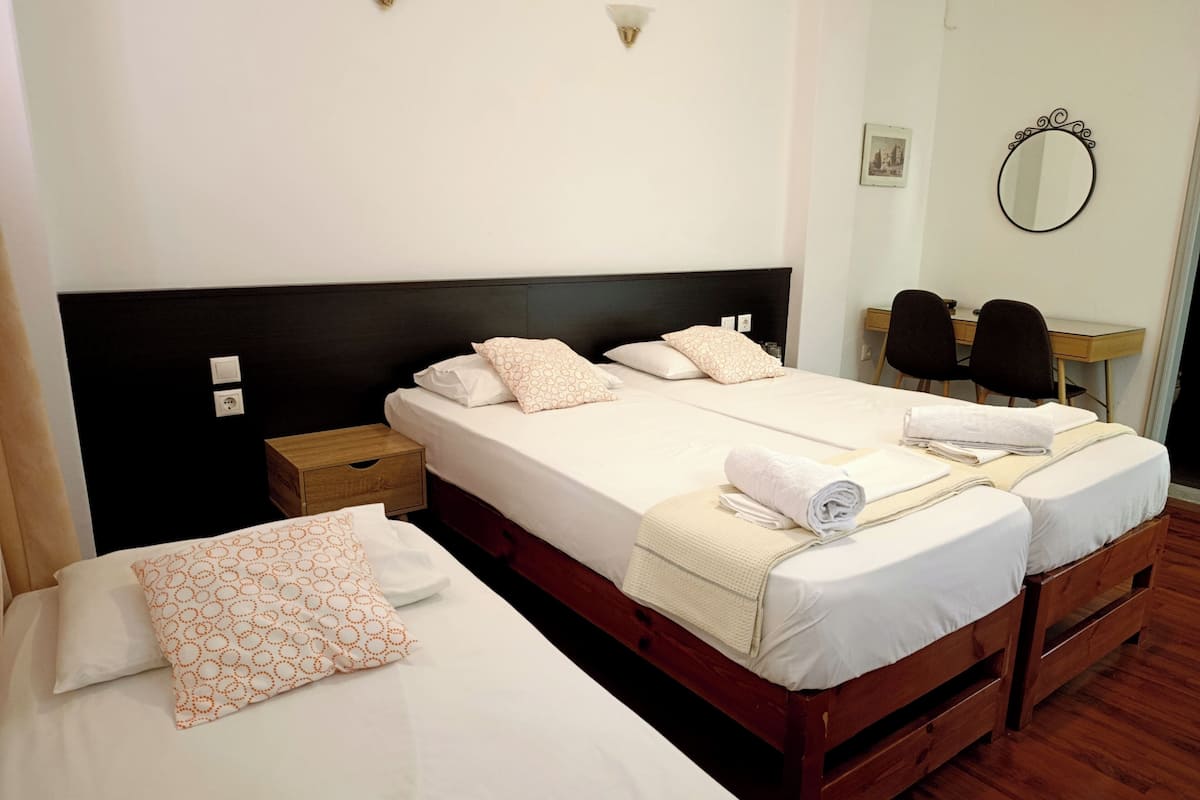 A double bed with a wooden headboard, a bedside table, and a chair.