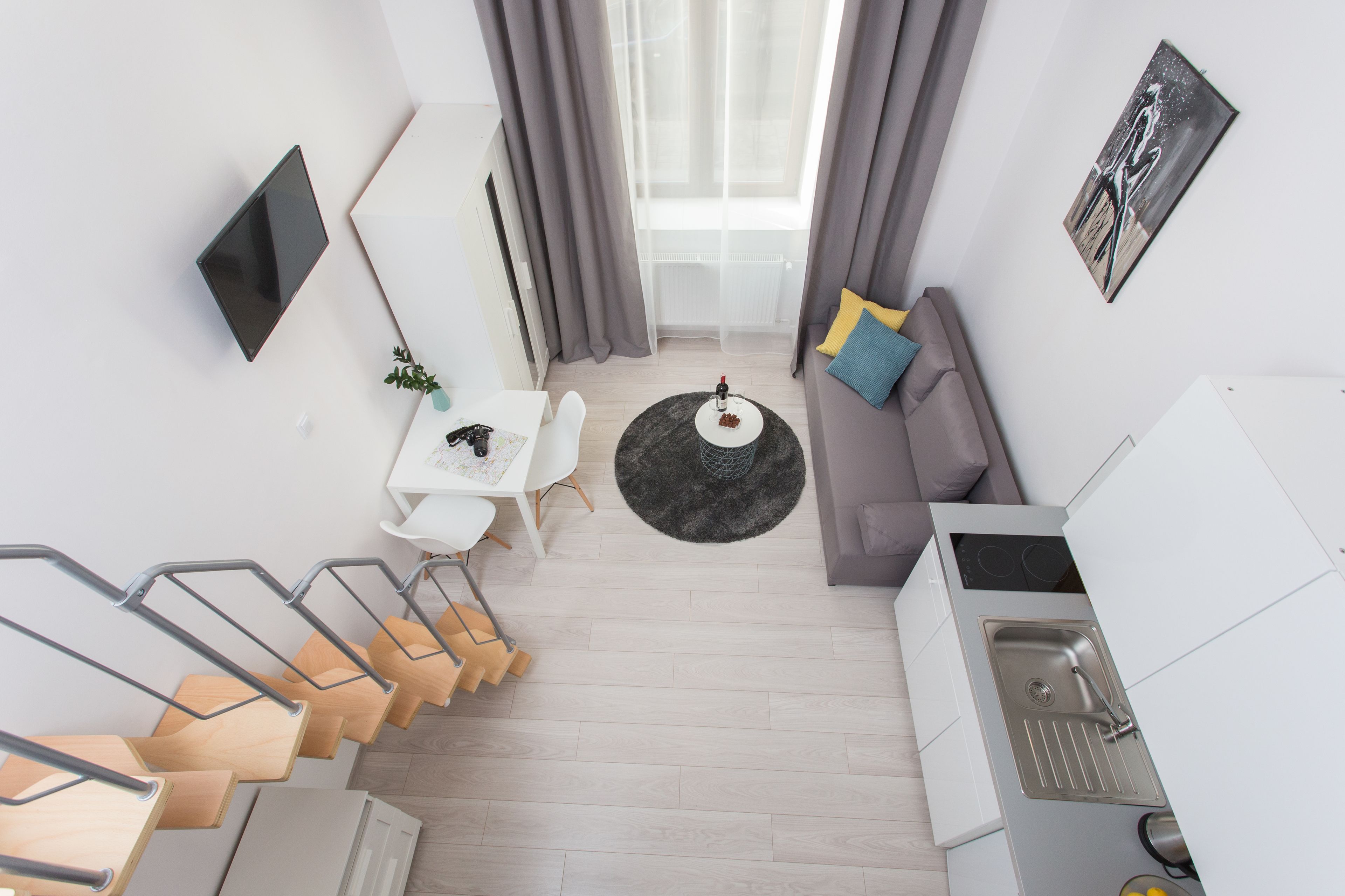 Un apartamento moderno con comedor, cocina y sala de estar con sofá y televisor.