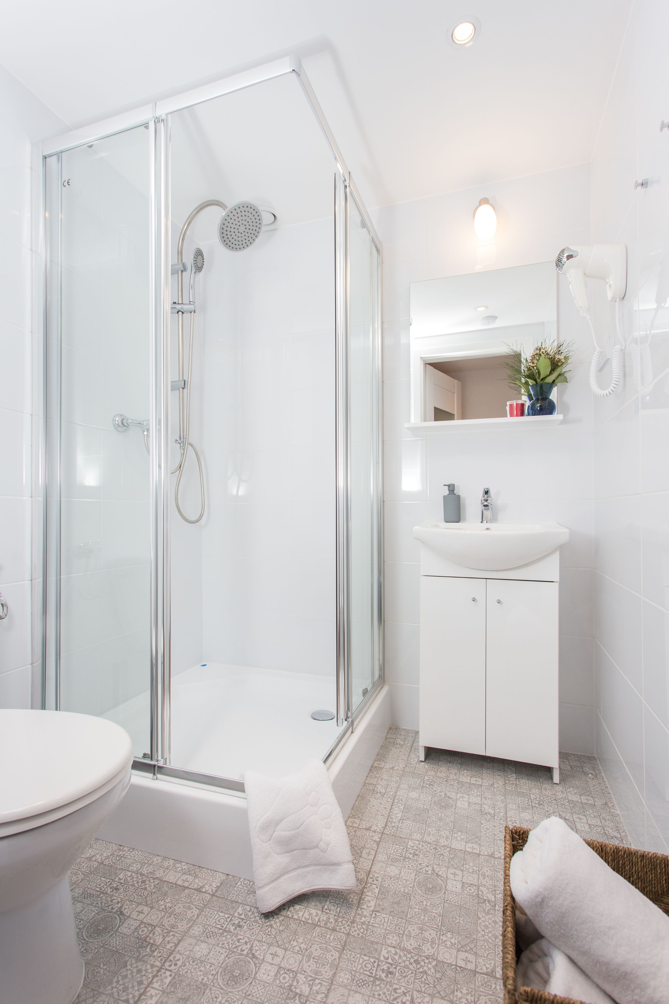 Un bagno moderno con doccia vetrata, lavandino bianco e water.