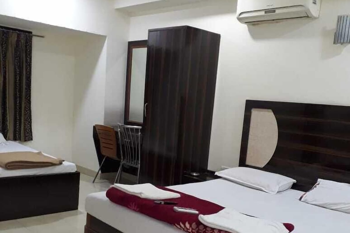 Une chambre d’hôtel équipée d’un grand lit, d’un bureau, d’une chaise, d’une armoire et d’un appareil de climatisation.