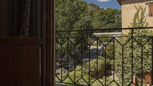 A view from a balcony with a metal railing, a clear blue sky, and a large cloud. - Hotel Anna (Cocentaina)