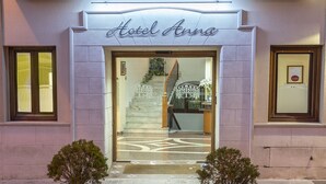 The entrance to Hotel Anna with a marble staircase leading inside, potted plants on either side, and a sign above the door. - Hotel Anna (Cocentaina)