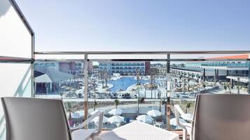 Een balkon met uitzicht op een zwembad en een hotelgebouw.
