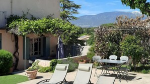 Une terrasse avec des meubles d’extérieur, une pergola et une vue sur une montagne.