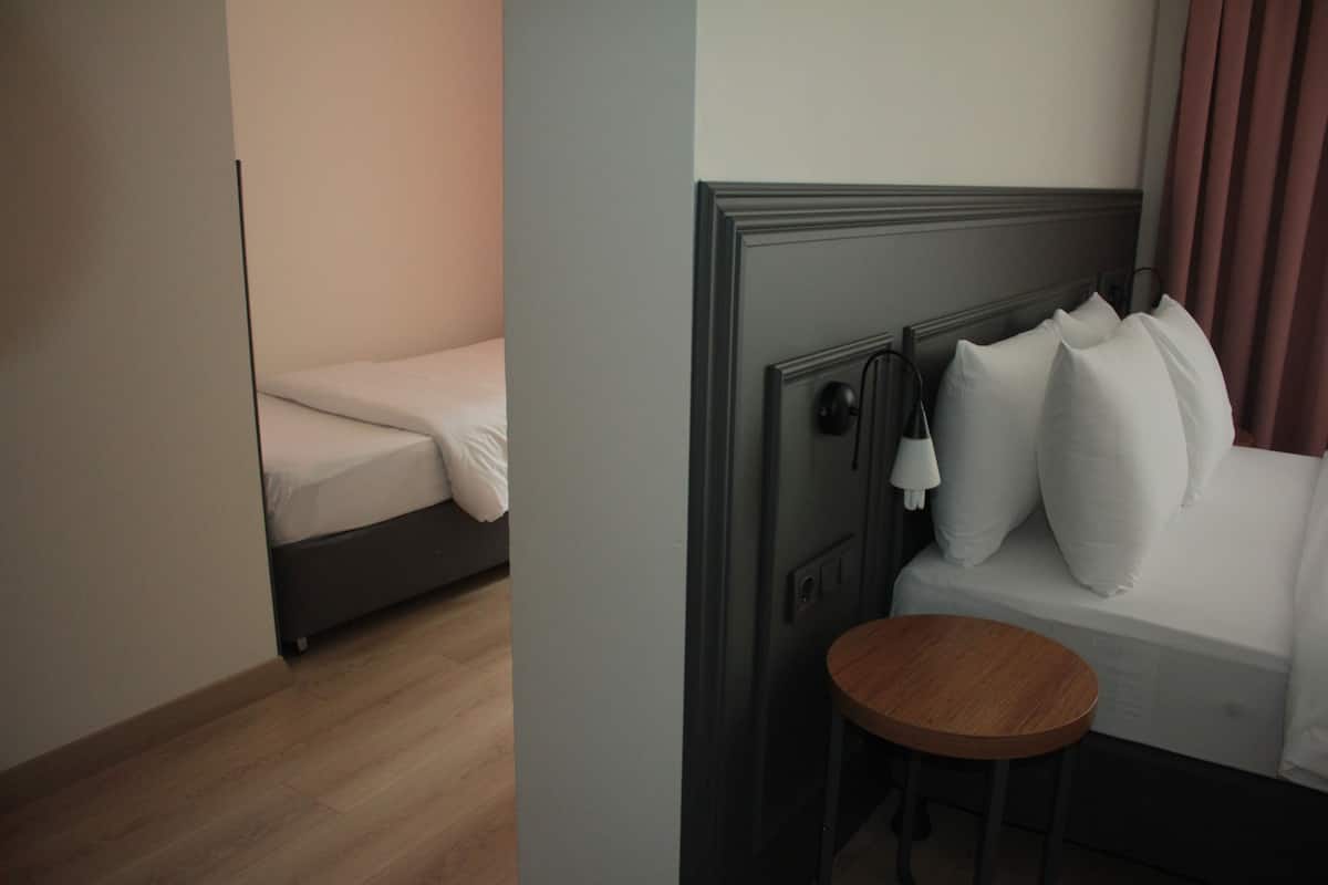 Une chambre d’hôtel avec un lit simple, une petite table ronde et une table de chevet.