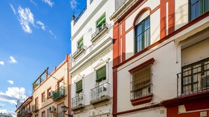 Un vicolo stretto con edifici a più piani, caratterizzati da balconi, finestre e dettagli architettonici tradizionali.