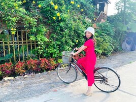 Una persona en bicicleta en un jardín con cerda y plantas.