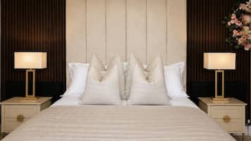 A hotel room with a large bed, two bedside tables, and a headboard with vertical slats.