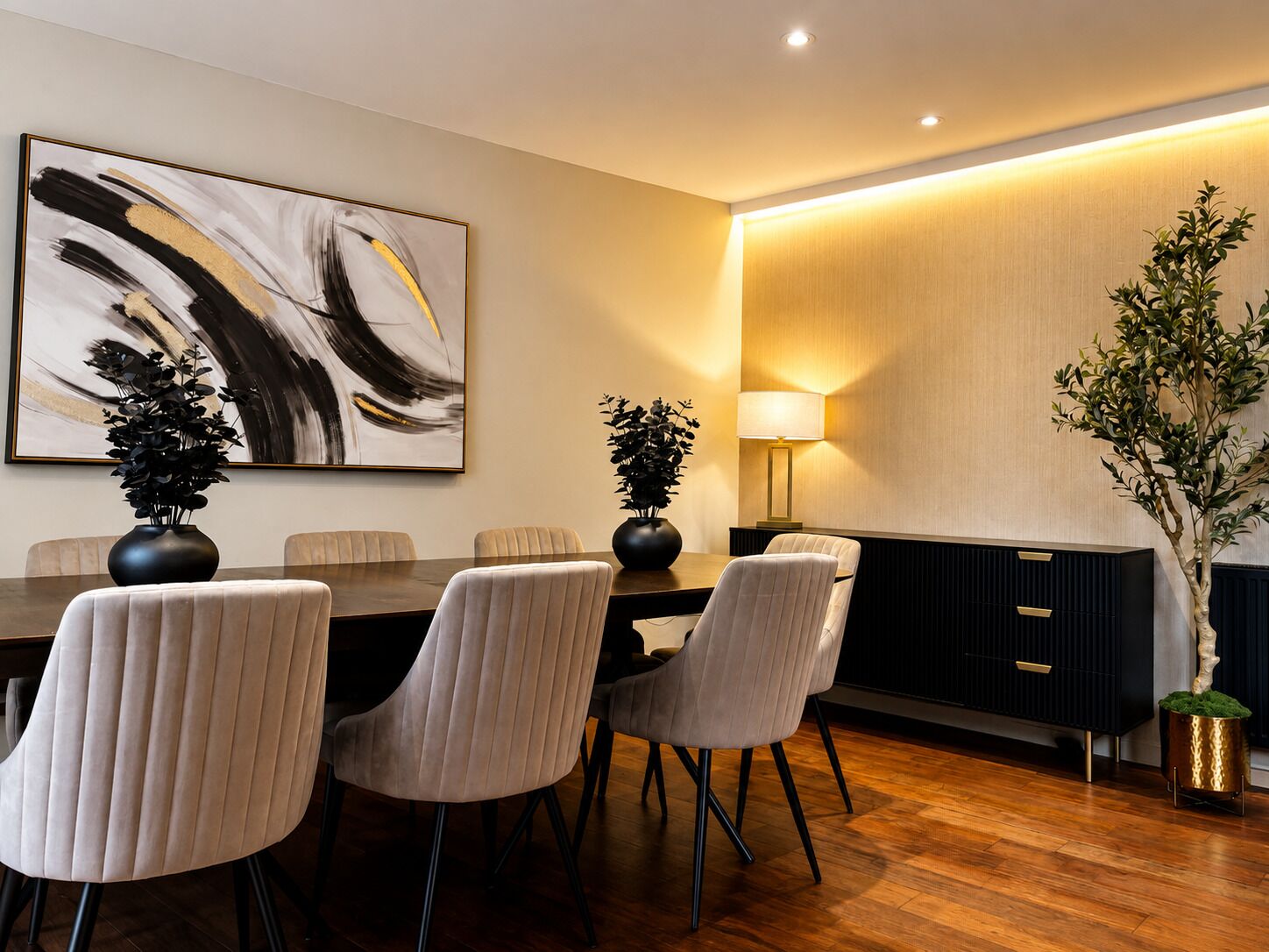 Ein moderner Essbereich mit einem langen Tisch, sechs Stühlen, einem großen abstrakten Gemälde, einer Stehlampe und einem Blumentopf.