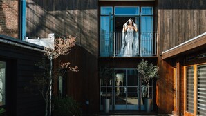 A modern two-story building with a balcony, large windows, and a wooden facade. - Cedar House at The Old Fire Station (Canterbury)