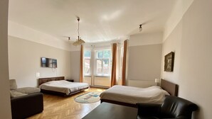 A modern hotel room with two beds, a sofa, a table, and a TV. - Casa Balcescu (Brasov)