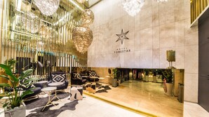 A modern hotel lobby with a star logo, elegant furniture, and decorative lighting. - Hotel Forestar (Seoul)