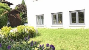Un edificio blanco con tres ventanas y un césped bien cuidado.
