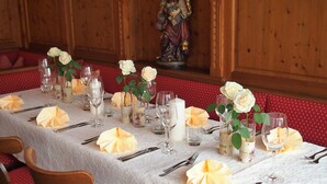 Una mesa de comedor dispuesta con mantel blanco, cristalería y plegados de servilleta amarillos.