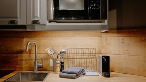 A modern kitchen with a stainless steel sink, wooden countertop, and a microwave above. - (4) Ferienwohnung 28 qm, Dusche/WC, Kochnische und Balkon (Reit im Winkl)