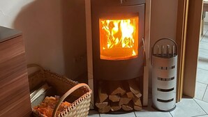 Uma lareira a lenha com chaminé, uma cesta de lenha e um cesto de lixo.