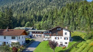Eine Berghütte mit Parkplatz, Zimmern und einem Restaurant.