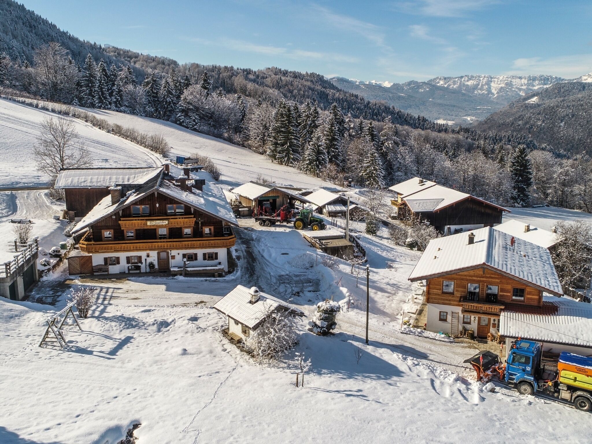 Un pueblo en la montaña cubierto de nieve con edificios de madera, un telesilla y una vista despejada de las montañas circundantes.