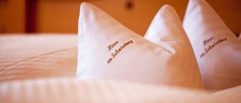 Una cama con almohadas que tienen texto.
