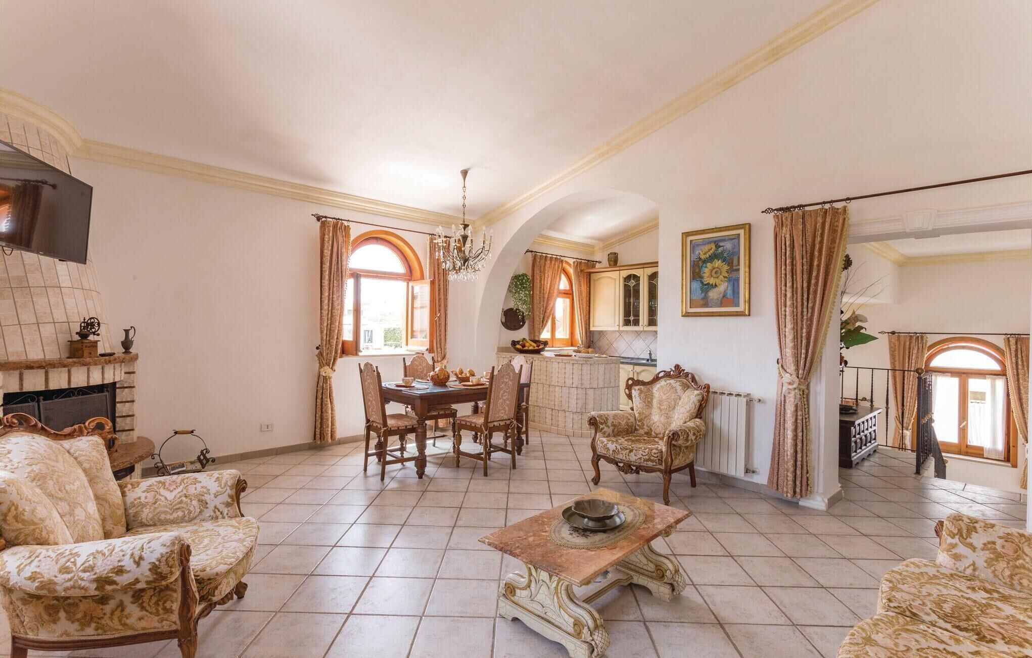 A spacious living room with a fireplace, dining area, and kitchen.