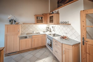 A kitchen with wooden cabinets, a tiled backsplash, a built-in oven, and a sink.