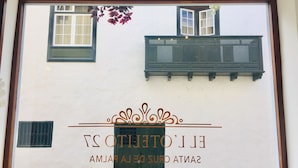 Fachada de edificio con ventana, balcón y detalles decorativos.